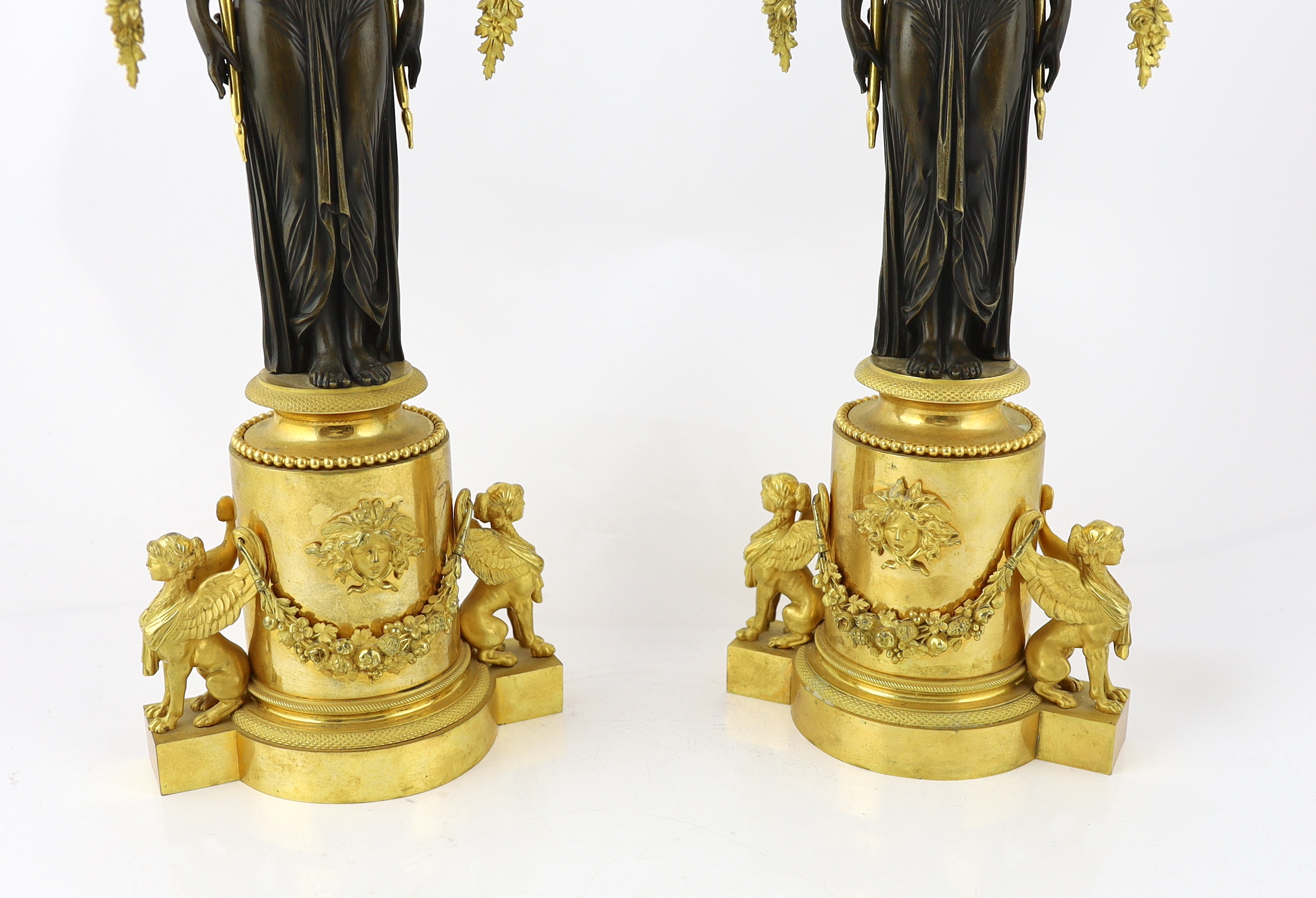 A pair of late 19th century French Empire style bronze and ormolu three light candelabra, 20cm wide, 63cm high, Please note this lot attracts an additional import tax of 5% on the hammer price